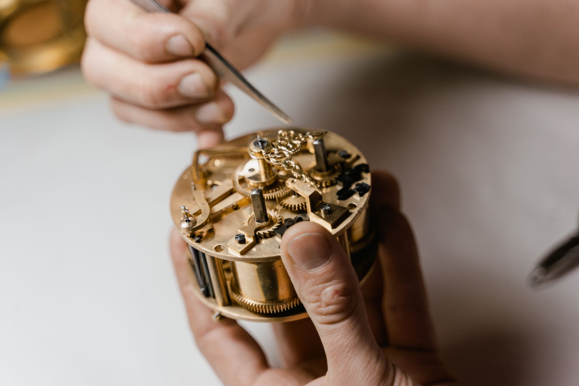 Watchmaker-at-work A detailed view of a watchmaker fixing a clock mechanism highlighting precision and skill.